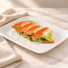 Koçak Söbiyet baklava: four triangular pieces of golden phyllo with a green Antep pistachio filling on a white plate